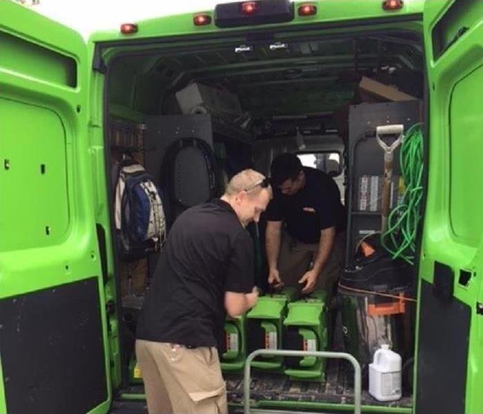 SERVPRO crew with equipment loading a truck.
